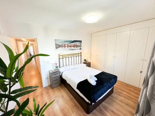 een slaapkamer met een bed en een plant erin bij El Puente del Pilar ComoTuCasa in Zaragoza