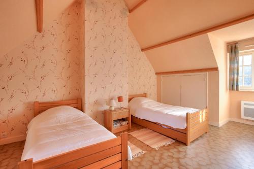 1 Schlafzimmer mit 2 Betten und einem Fenster in der Unterkunft Parenthese familiale entre plage et golf in Pléneuf-Val-André