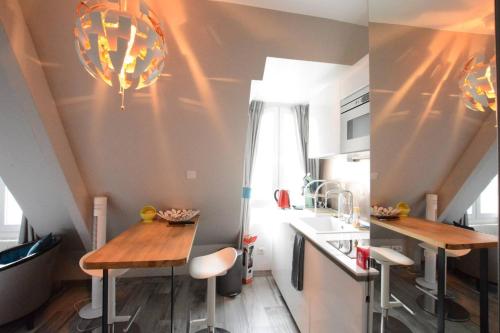 une petite cuisine avec une table et un évier dans l'établissement Victor Hugo - Splendid flat near Eiffel Tower, à Paris