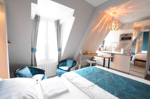 Cet appartement comprend une chambre avec un lit et deux chaises ainsi qu'une cuisine. dans l'établissement Victor Hugo - Splendid flat near Eiffel Tower, à Paris