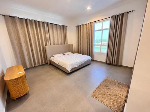 ein Schlafzimmer mit einem Bett und einem großen Fenster in der Unterkunft 4 Bedrooms villa for rent in Al Ḩamīdīyah
