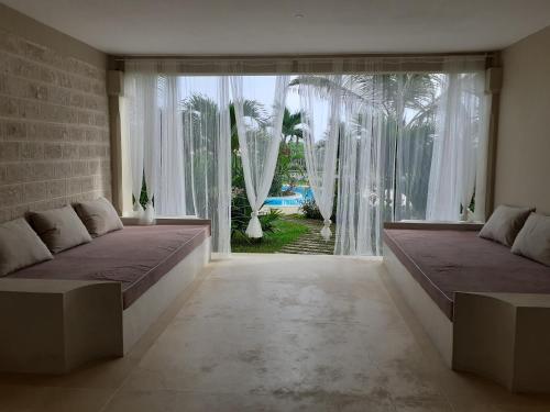 a bedroom with two beds and a large window at GIORGIA HOUSE WATAMU BEACH in Watamu