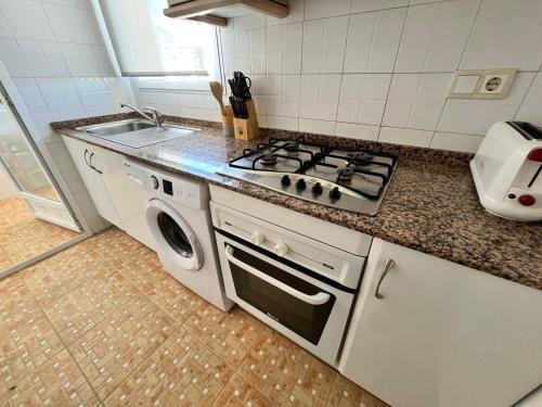 a kitchen with a stove top oven next to a sink at Neptuno View 22 in Benidorm