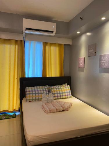 1 dormitorio con 1 cama con 2 toallas en Sea Residences, en Manila