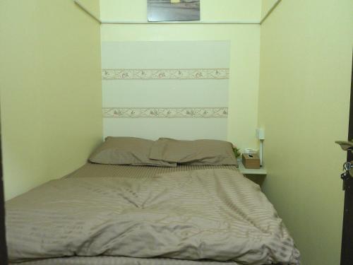 Una cama en una habitación pequeña con avertisementatronatronstrationstrationstration en Ruby Star Hostel 21 Dubai, en Dubái