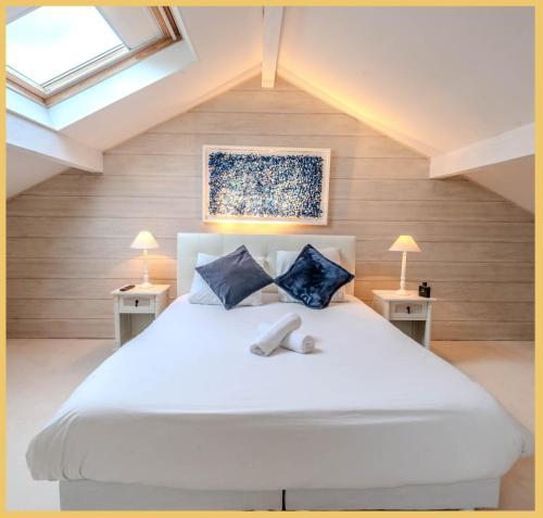 una camera da letto con un grande letto bianco con due tavoli di Villa T6 I Luxury I Marcellaz a Marcellaz