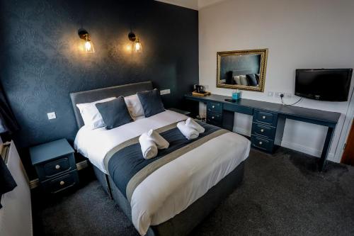 a bedroom with a large bed and a television at Cumbria Park Hotel in Carlisle