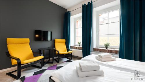 a bedroom with two chairs and a bed and a table at Flatbook - City Center Apartments Waterlane Vintage with Gym in Gdańsk