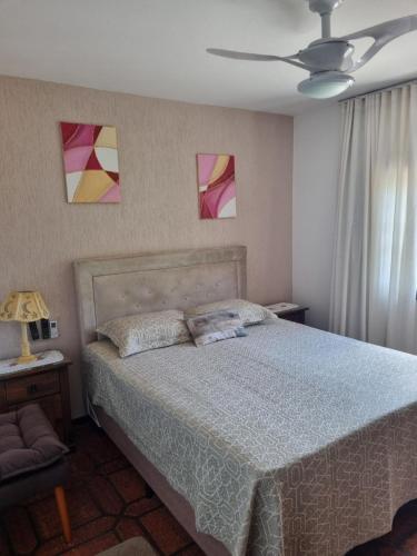 1 dormitorio con 1 cama y 2 cuadros en la pared en Apartamento com Vista ao Mar, en Bombinhas