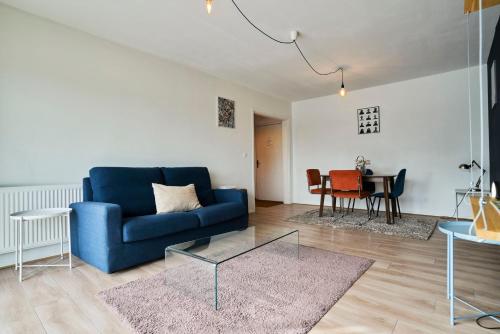 un salon avec un canapé bleu et une table dans l'établissement Euralille: Apartment with balcony!, à Lille