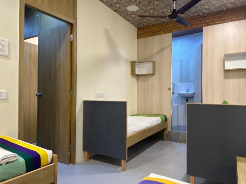 a small room with two beds and a bathroom at ZEST STAYS - IIT in Mumbai