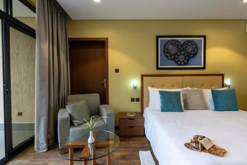a hotel room with a bed and a chair at Mantis Kivu Marina Bay Hotel in Muhari