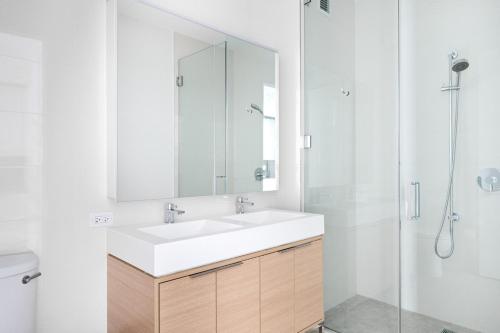 een badkamer met een witte wastafel en een douche bij FiDi 1BR w Gym WD nr S St Seaport NYC-536 in New York
