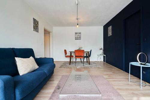 un salon avec un canapé bleu et une table dans l'établissement Euralille: Apartment with balcony!, à Lille