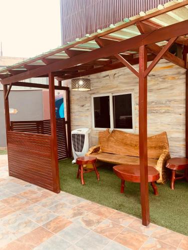 a rv with a bench and a table and two chairs at Bays Lodge, Accra in Accra
