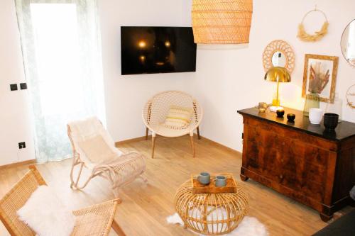 a living room with two chairs and a table at Les Blés Dorés et Les Graines de Lin, 2 gîtes à la Ferme avec moutons et piscine, à côté de Beaune in Corgengoux