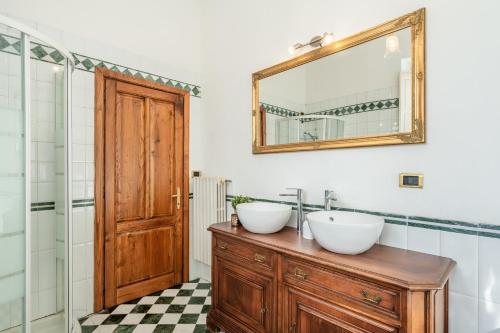 a bathroom with two sinks and a mirror at Busdraghi Luxury Apartment in Lucca
