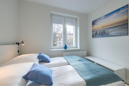 Schlafzimmer mit einem Bett und einem Fenster in der Unterkunft DR Apartments - Seadream in Sopot