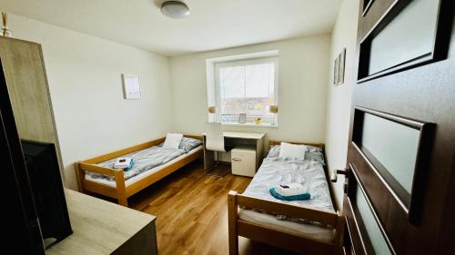 ハヴィジョフにあるTennisHill Havířovのベッド2台、デスクが備わる小さな客室です。