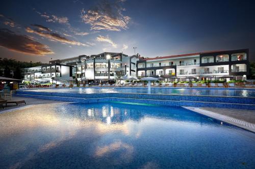 ein großes Schwimmbad vor einem Gebäude in der Unterkunft Trypiti Resort Blue Dream Palace and Hive Water Park in Limenaria