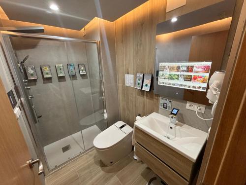 a bathroom with a shower and a toilet and a sink at Futurotel Granada Dreams in Granada