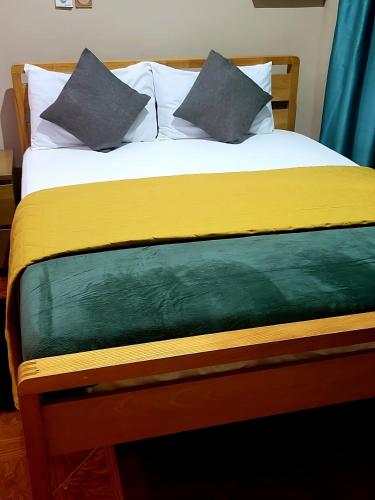 a bed with two pillows on top of it at GHouse in Adentan
