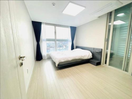 a bedroom with a bed and a large window at Super quiet Dry bath floor OLED TV Closet room in Seoul