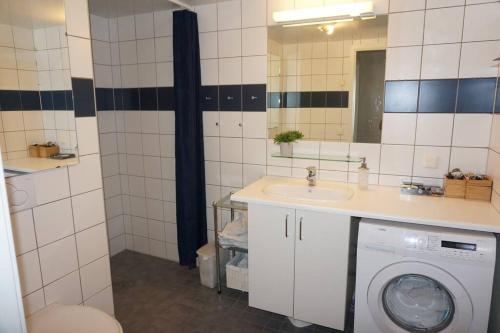 a bathroom with a washing machine and a sink at Top floor apartment in Stavangers best area! in Stavanger