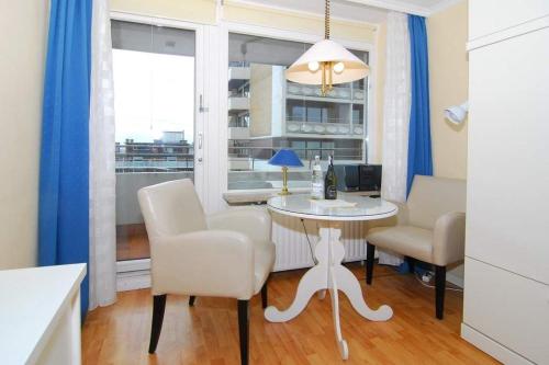 una sala da pranzo con tavolo, sedie e finestra di Metropol, Whg 61a, Landseite a Westerland
