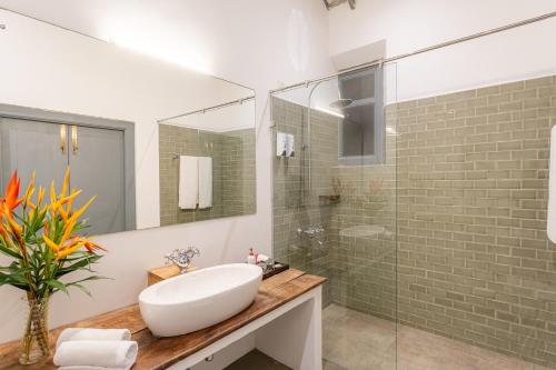 a bathroom with a sink and a glass shower at The Dutch Bungalow in Galle