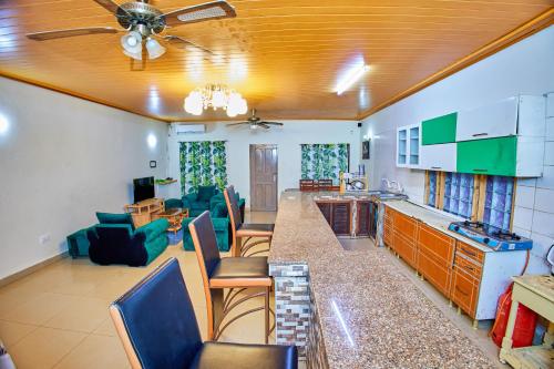 uma cozinha e sala de estar com sofá e cadeiras em Diani Home Stays em Diani Beach