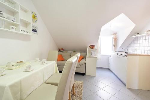 a white living room with a table and a kitchen at Apartment Kovac Old Town 2 in Dubrovnik