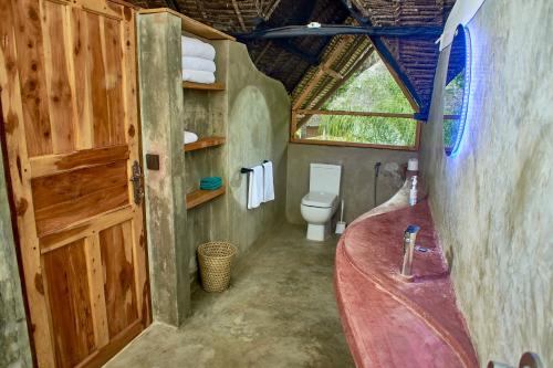 a bathroom with a sink and a toilet in a room at Lions' Luxury Eco Resort & Spa in Malindi