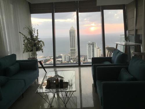 a living room with two blue couches and a glass table at Luxe Colombo Heights in Colombo