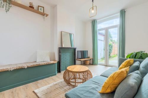 uma sala de estar com um sofá azul e uma mesa em 4 bedroom house with garden em Marcq-en-Baroeul