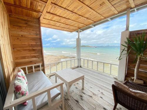 a porch with a bed and a view of the ocean at บ้านฟ้าใส รีสอร์ท เกาะล้าน in Ko Larn