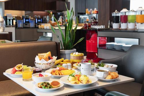 a table with plates of food on top of it at Pullman Bangkok King Power in Bangkok