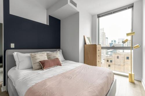 a bedroom with a large bed with a large window at Loop 1BR w Gym Pool WD nr Millennium Park CHI-227 in Chicago
