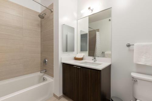 a bathroom with a sink and a tub and a mirror at Loop 1BR w Gym Pool WD nr Millennium Park CHI-227 in Chicago