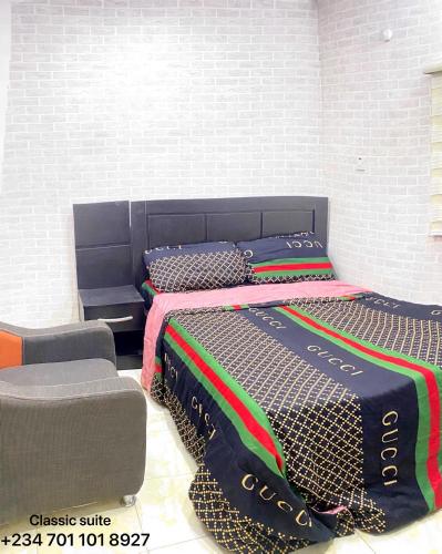 a bedroom with two beds and a chair at DIVINE VILLA AND RESORTS HOTEL GUEST House 15 mins Near Michael Okpara University Sam Mbakwe Airport in Umuhu