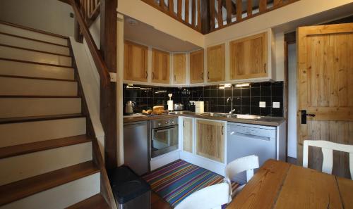 una cucina con armadi in legno e tavolo in legno di Badger Cottage at Alde Garden a Saxmundham