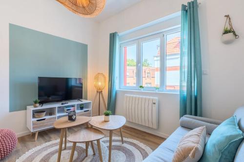 un salon avec un canapé et une télévision dans l'établissement 2 bedroom apartment near tram, CHR + parking, à Roubaix