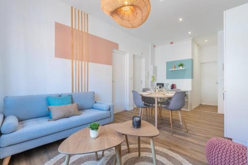 un salon avec un canapé bleu et une table dans l'établissement 2 bedroom apartment near tram, CHR + parking, à Roubaix