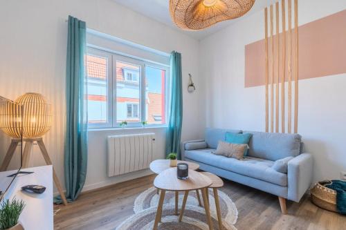 un salon avec un canapé bleu et une table dans l'établissement 2 bedroom apartment near tram, CHR + parking, à Roubaix