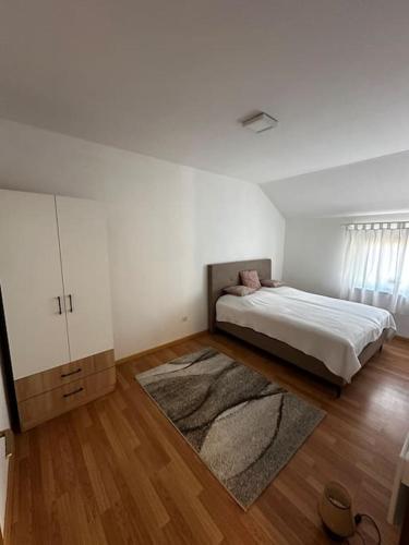 a white bedroom with a bed and a rug at Milincic‘s 2 Zimmerwohnung in Banja Luka