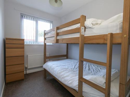 a bedroom with two bunk beds and a window at Sandy Toes in Swanage