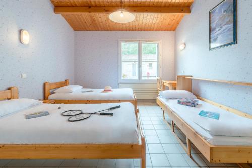 una stanza con tre letti con forbici di Azureva Longeville a Longeville-sur-Mer