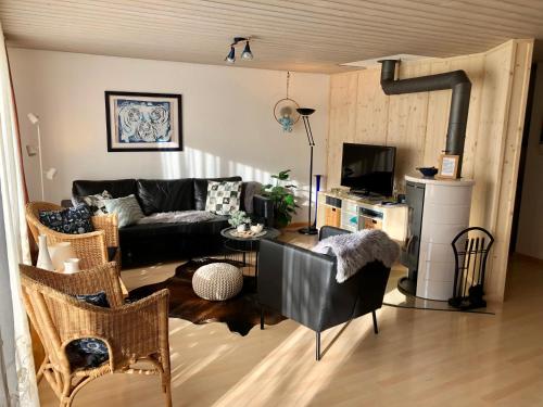 a living room with a couch and a tv at Ferienwohnung am Tor zum Berner Oberland in Steffisburg