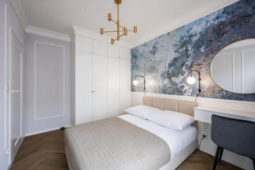 a bedroom with a bed and a desk and a mirror at Native Apartments Orawska 14/127 in Krakow