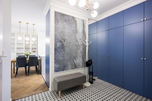 a living room with blue cabinets and a table at Native Apartments Orawska 14/127 in Krakow